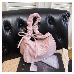 Gros plan du sac en velours côtelé rose avec broderie nœud et bandoulière plissée