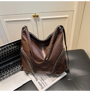 Détail d'un grand sac hobo marron foncé avec fermetures éclair décoratives