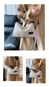 Detail of a beige canvas shoulder bag with black leather trim and adjustable strap