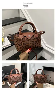 Detail of coffee leopard print handbag showing leather handle and metal zipper closure