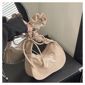 Détail du sac en velours côtelé beige avec nœud brodé et anse froncée tendance