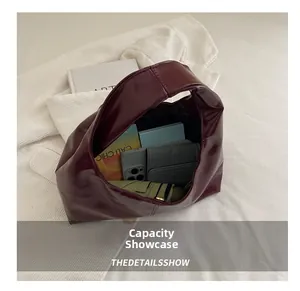 Top view of deep red leather tote bag interior showing spacious capacity with daily items