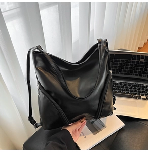Détail d'un grand cabas en cuir PU noir brillant avec des fermetures éclair décoratives