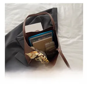 Detailed interior of large brown leather tote bag showing ample storage and silk scarf detail