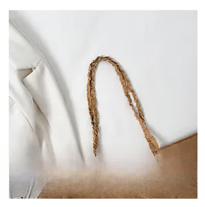 Close-up of golden chain strap intertwined with brown leather on quilted shoulder bag