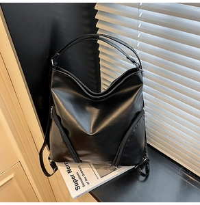Détail d'un sac cabas en similicuir noir mat avec fermetures éclair et texture cuir