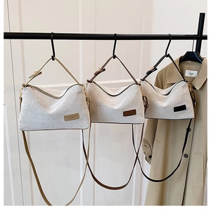 Detailed view of canvas patchwork bags in khaki, coffee, and black leather styles