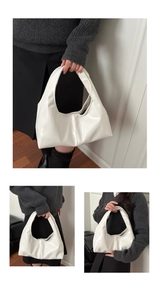 Detail of white glossy leather handbag with seamless integrated handle and stitch design