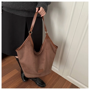 Détails du sac cabas marron en daim avec finitions en cuir et boucles métalliques