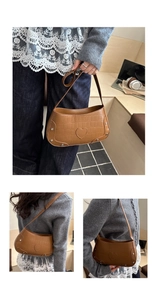 Close-up of brown crocodile texture leather bag with silver rivets and heart patch