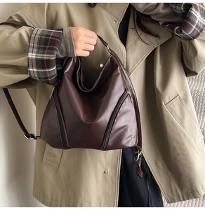 Détail du sac à main marron foncé en similicuir avec double fermeture éclair métallique