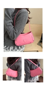 Detailed view of pink croc-embossed underarm bag with heart patch and metal rivets