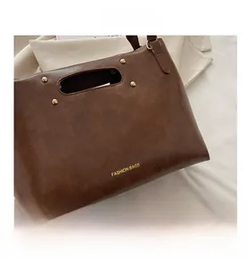 Detail of vintage brown leather handbag with gold rivets and Fashion Bags gold lettering
