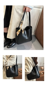 Detail of black leather tote bag with elegant silk scarf and magnetic metal clasp