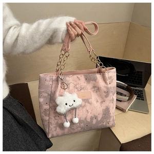 Detailed view of pink canvas tote bag with star patterns and cloud charm accessory