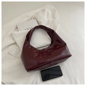Close-up of wine red glossy hobo bag with a smartphone showing its actual size
