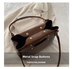 Close-up detail of premium brown leather bag with secure metallic snap button fasteners