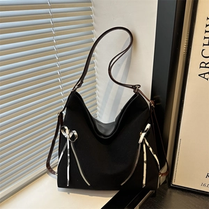 Chic black canvas tote bag with decorative bow zippers and brown leather straps