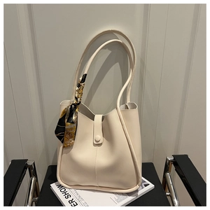 Close-up of cream tote bag featuring high-quality leather texture and silk scarf detail