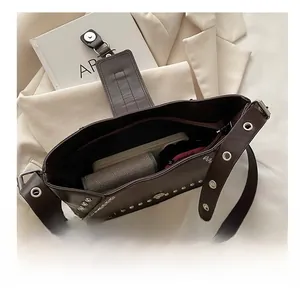 Top view of vintage rivet shoulder bag interior showing daily essentials and zip closure