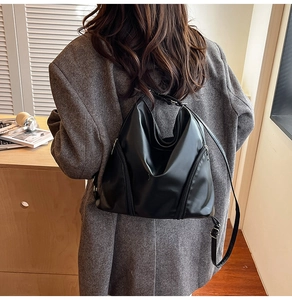Détail de la sangle réglable et du zip latéral sur un sac hobo en cuir noir
