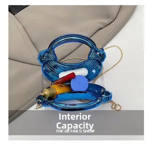Detail showing the internal capacity and blue shell-shaped acrylic bag with gold chain