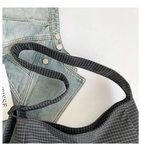 Détail du sac fourre-tout en toile à carreaux noir et blanc avec une simple bandoulière