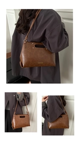 Detail of vintage brown shoulder bag showing rivet studs and cutout handle design