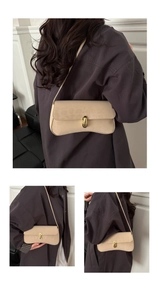 Close-up of beige curved hobo bag with animal pattern and golden metal buckle