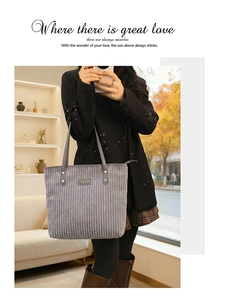 Detail of gray corduroy tote bag featuring vertical texture and leather handles with rivets