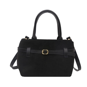 Minimalist matte black bucket bag with gold buckle detail and detachable shoulder strap