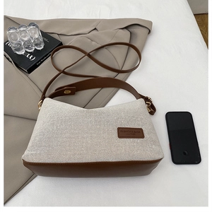 Close-up of retro canvas stitching shoulder bag with leather strap and fashion label
