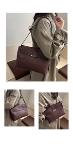 Detailed close-up of dark brown leather shoulder bag with vintage metal twist lock clasp