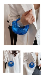 Detail of electric blue acrylic bag with spiral texture and golden chain strap