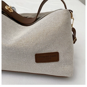 Detail of knit fabric and brown leather trim on a stylish crossbody shoulder bag