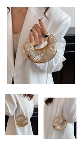 Detail of a metallic gold crescent bag with striped texture and chain strap