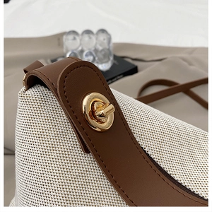 Macro shot of retro beige textured fabric crossbody bag with dark brown leather and gold lock