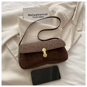 Detailed view of the leopard print suede bag texture with a gold metal clasp buckle