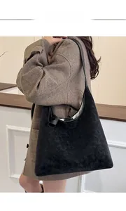 Classic black shoulder bag in vintage matte texture styled with a brown plaid blazer