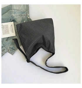 Détail du sac hobo en toile à carreaux montrant sa grande capacité et son tissu doux décontracté