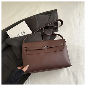 Close-up of brown leather handbag featuring silver twist lock and strap detail