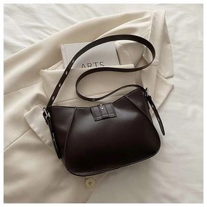 Détail d'un sac bandoulière en cuir marron foncé vintage avec boucle et rivets en métal