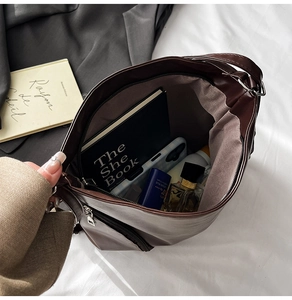 Intérieur spacieux d'un sac cabas marron foncé avec poche zippée et objets du quotidien