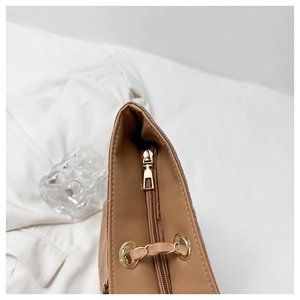 Detailed top view of brown textured tote bag featuring a gold zipper and smooth lining