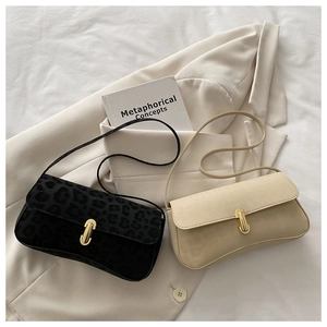 Detail of chic leopard print and beige shoulder bags with golden U-shaped buckles