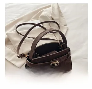 Detail view of the brown leopard print handbag featuring a gold twist lock and sturdy handle