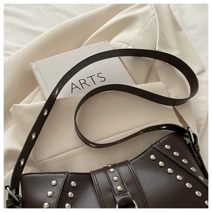 Détails de sac besace rétro marron foncé avec rivets argentés et bandoulière à œillets