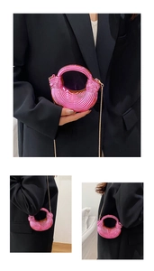 Detail of pink metallic textured mini bag with golden chain and round handle