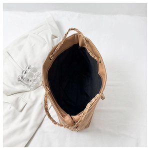Top view of khaki quilted tote bag showing spacious black interior and gold chain strap