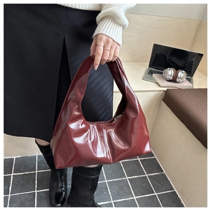 Detail of burgundy hobo bag in glossy leather with soft pleats and modern design